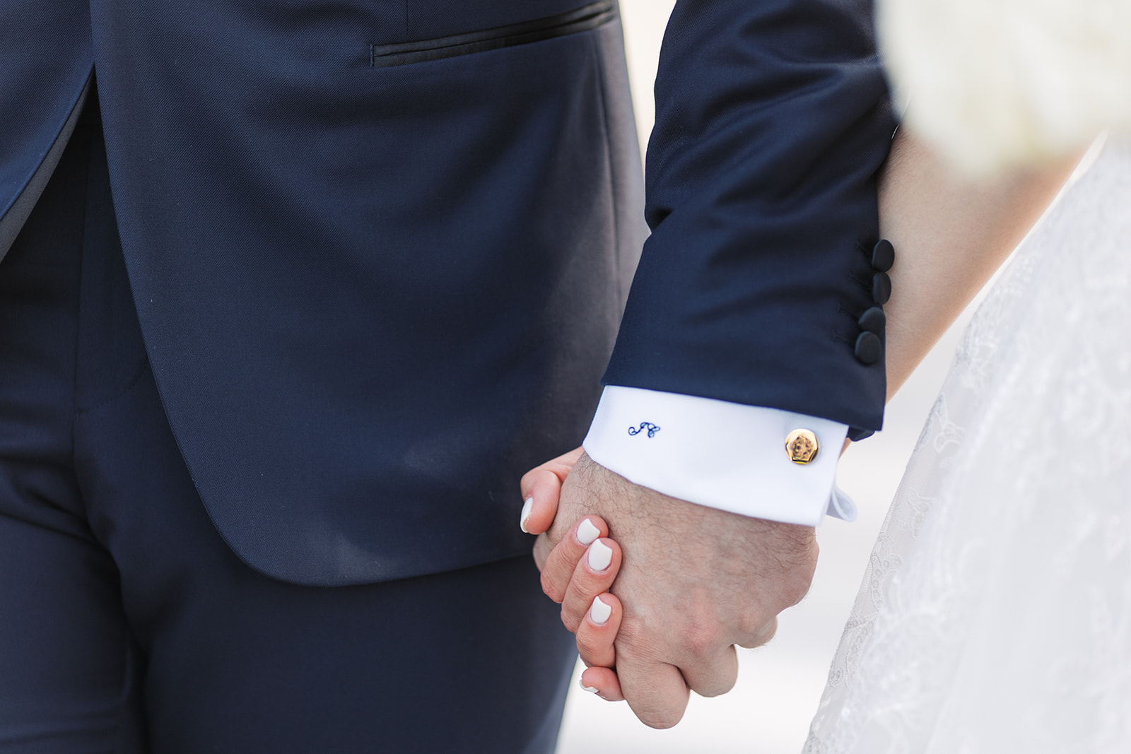 Newlyweds hold hands while walking
