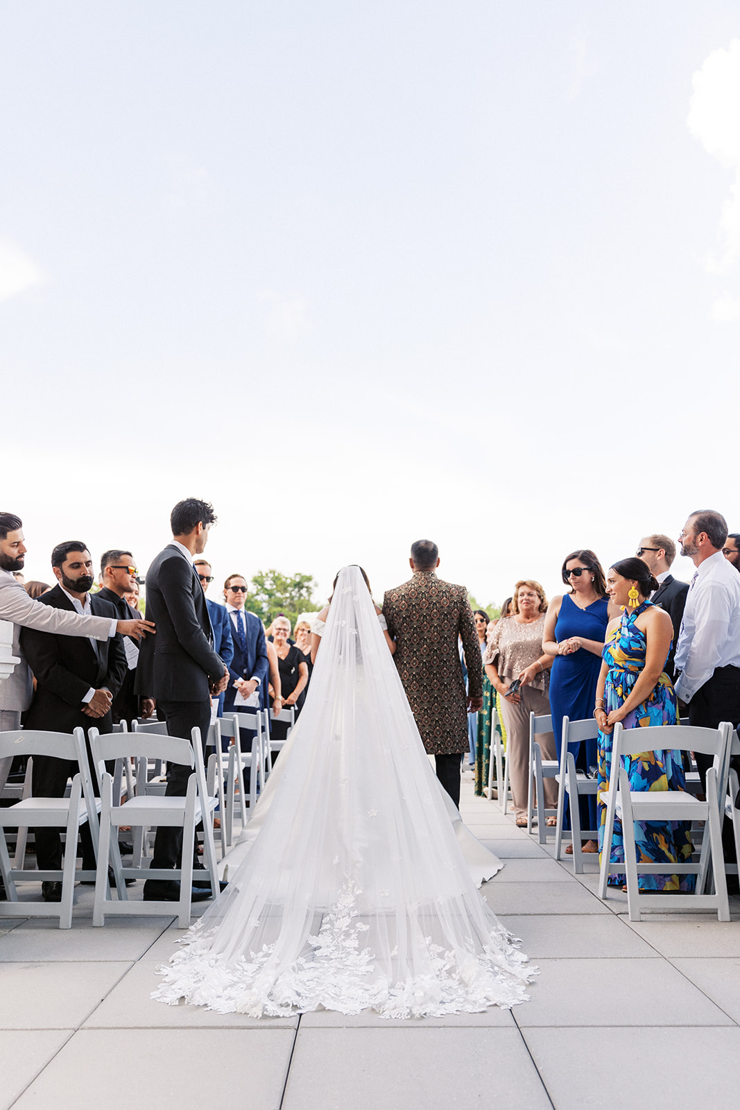 A father leads his bride down the aisle of her wedding