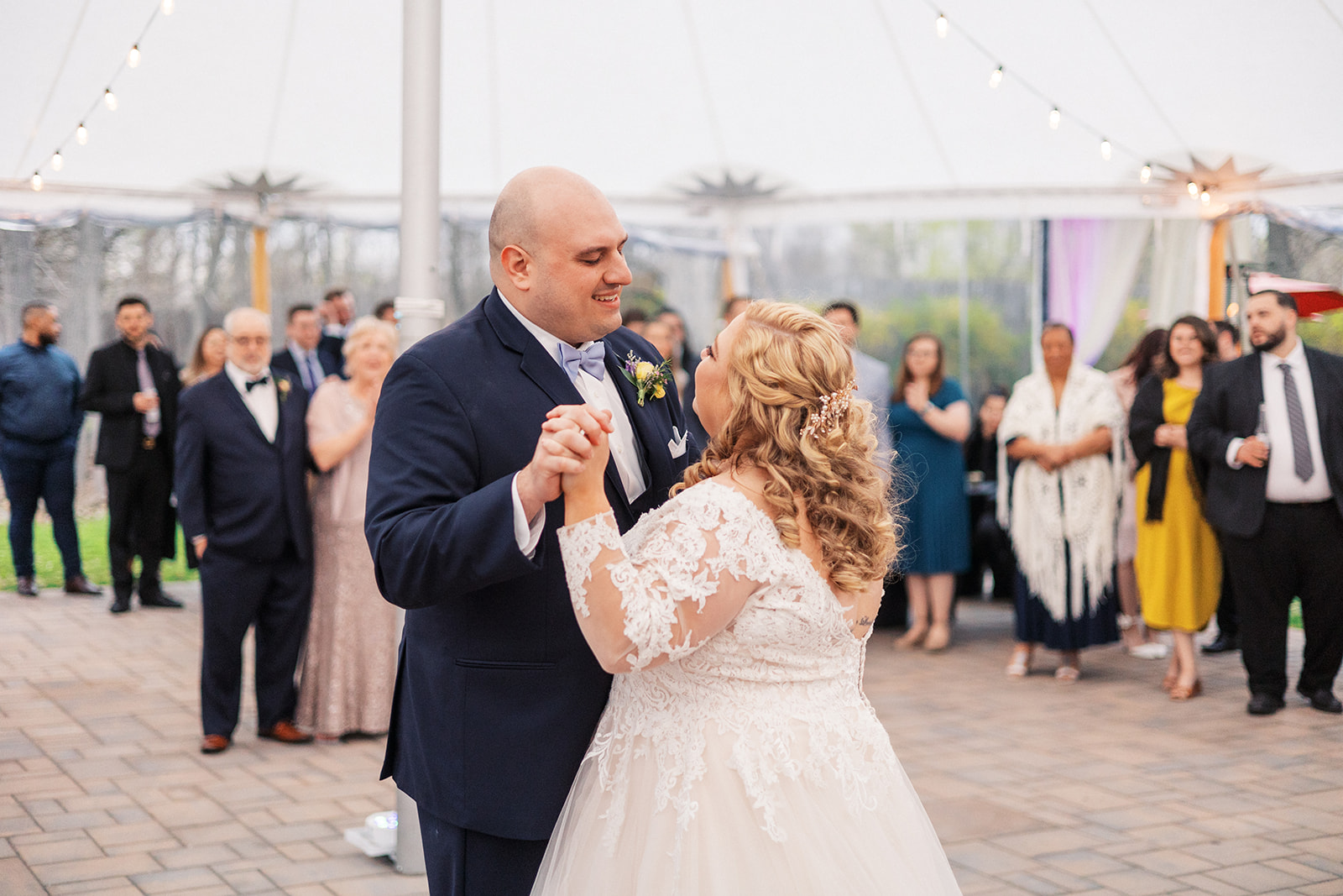 Newlyweds dance under a large white tent reception at their Forest Lodge Wedding