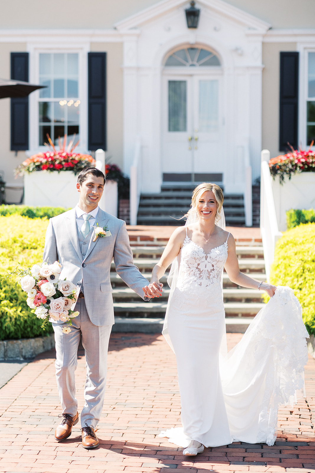 Newlyweds smile and hold hands while walking at their Pen Ryn Estate Wedding