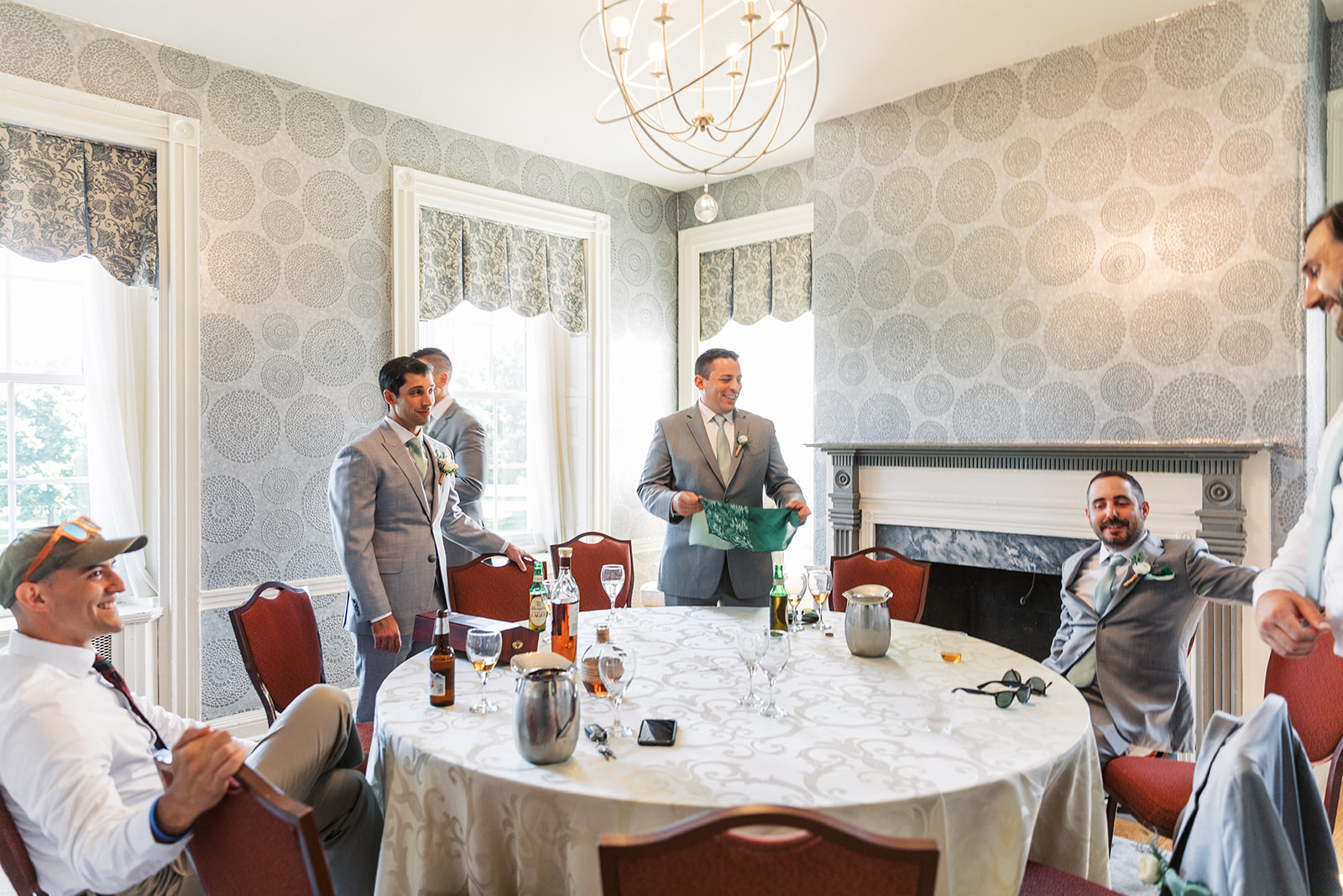 A groom gets ready with his groomsmen in grey suits