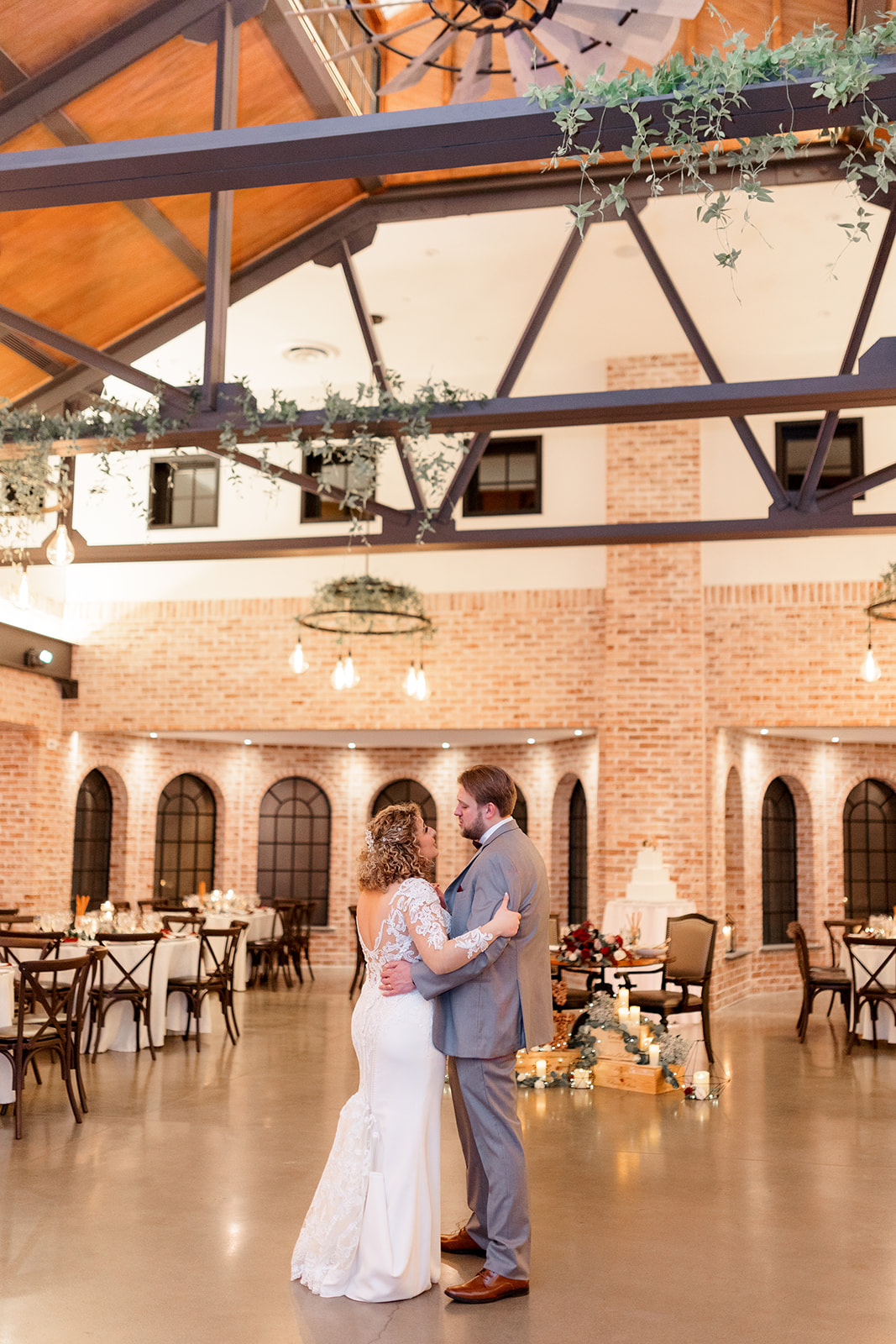 Newlyweds dance together in the empty The Refinery At Perona Farms wedding reception room