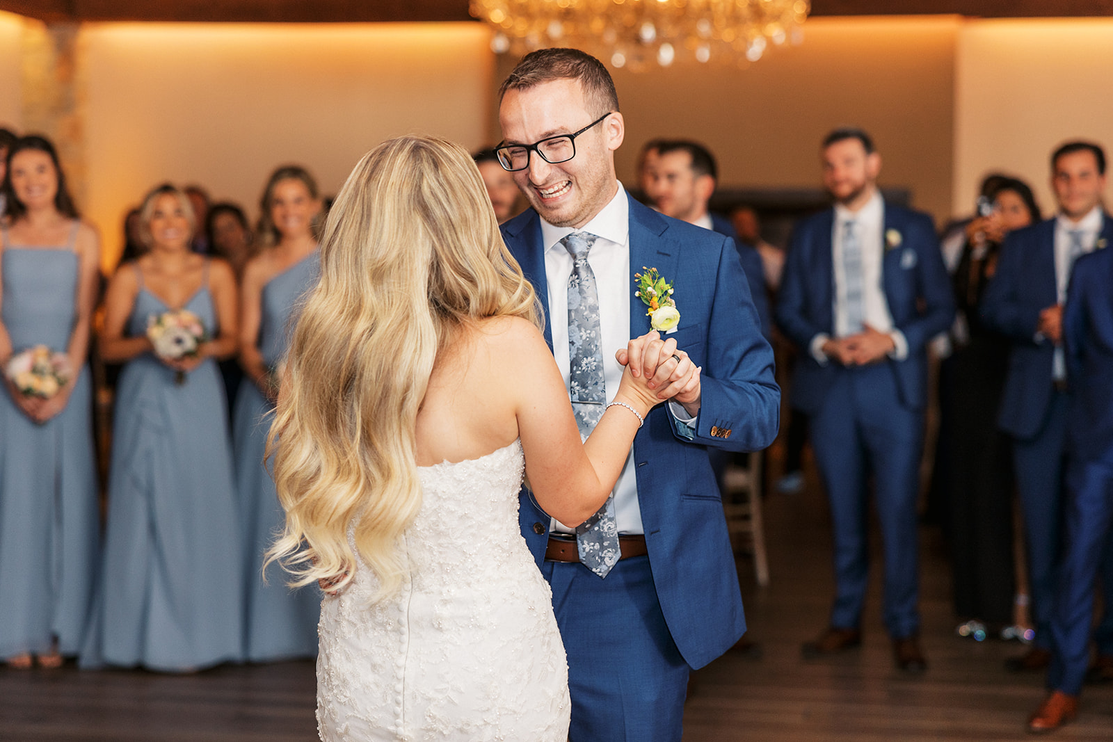 Newlyweds laugh and smile while dancing for the first time surrounded by their guests at their The Reserve At Perona Farms wedding reception