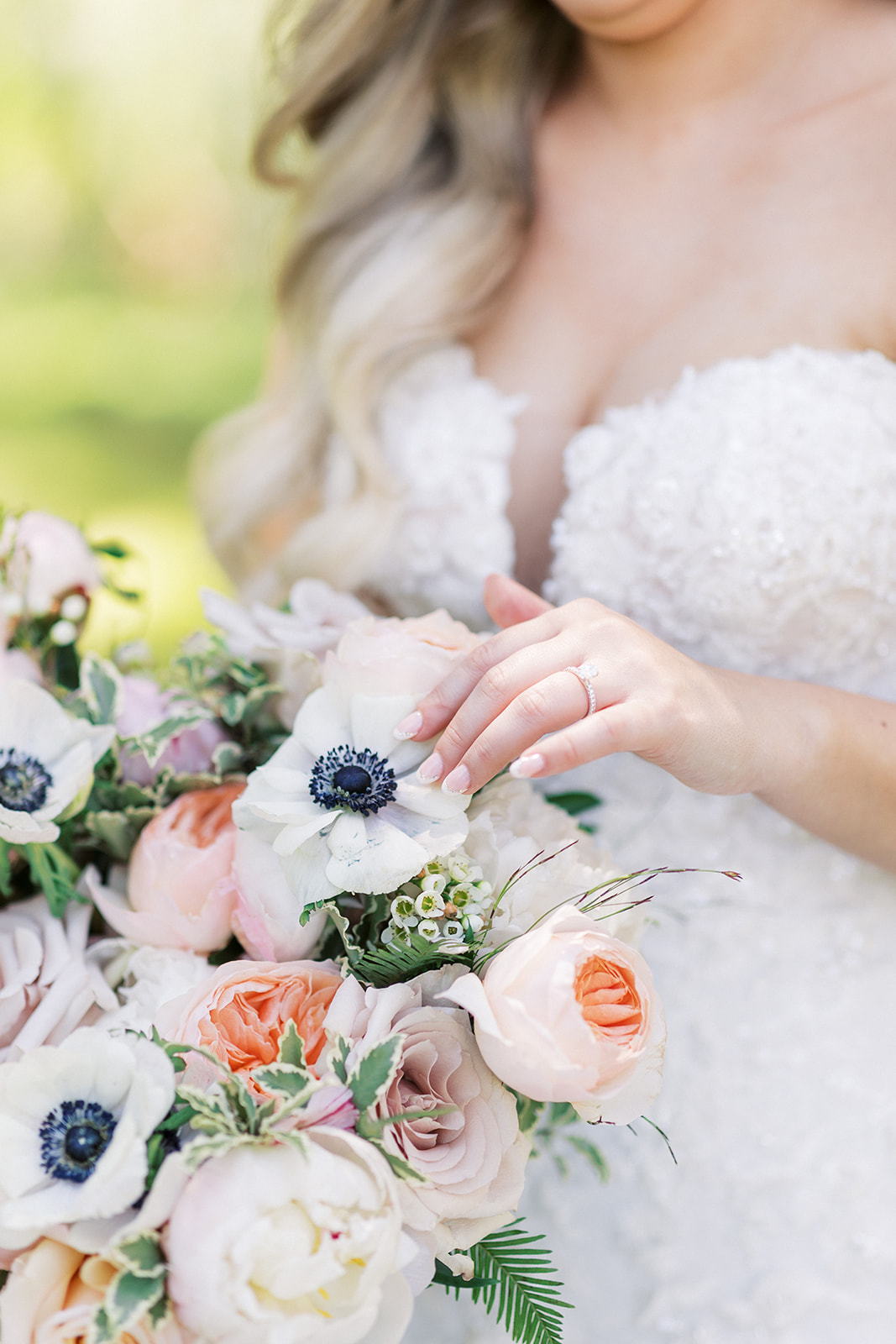A bride touches the flowers in her colorful bouquet