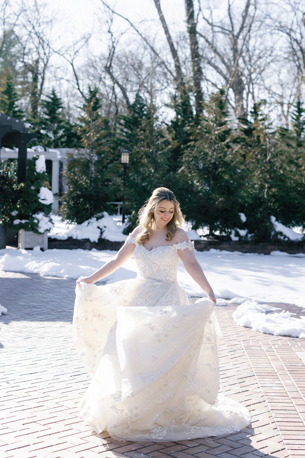 A bride twirls on a snowy patio in a garden at her Crest Hollow Country Club Wedding