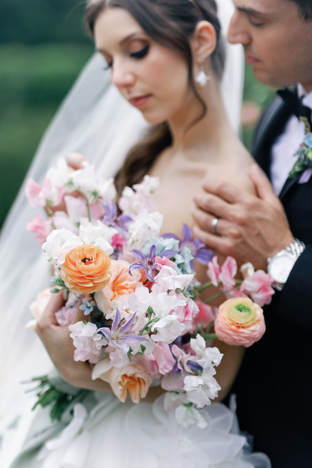 Newlyweds admire the bride's colorful bouquet at their Lake Valhalla Club wedding