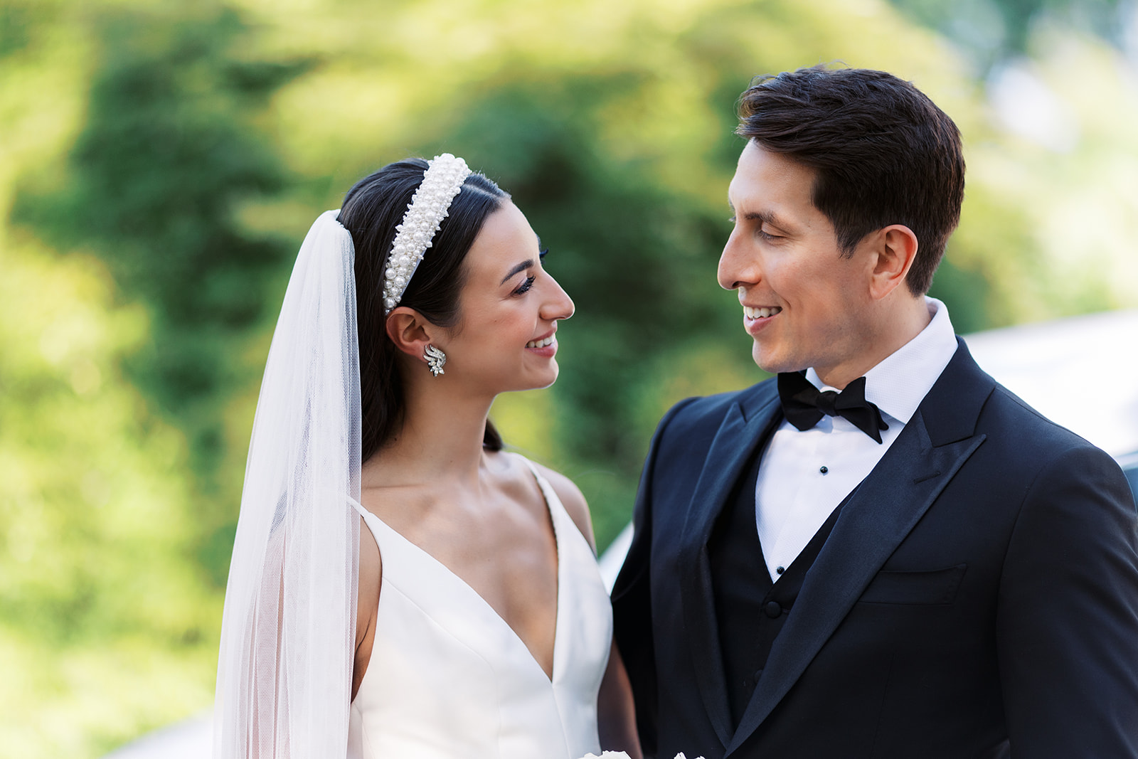 Newlyweds smile at each other while standing in a garden at their Molly Pitcher Inn Wedding