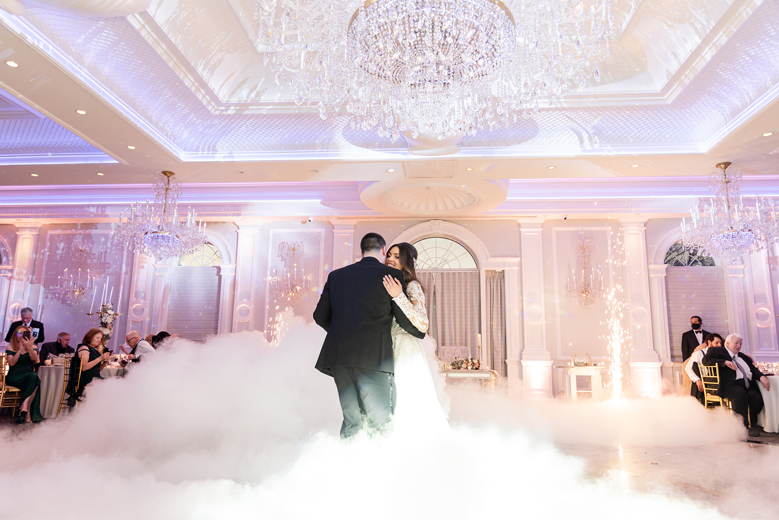 Happy newlyweds dance in a ballroom surrounded in ground fog at one of the New Jersey Mansion Wedding Venues