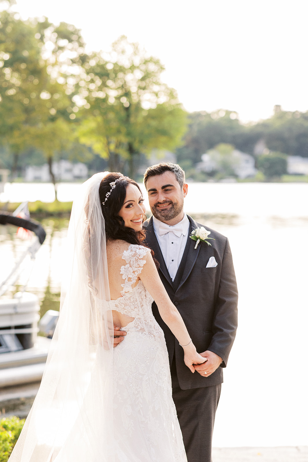 Happy newlyweds dance on a dock in a lace dress and black tux at one of the New Jersey Waterfront Wedding Venues