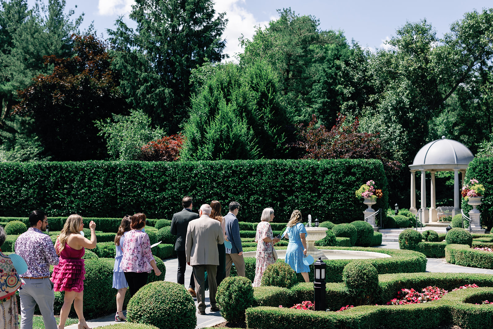 Guests wander the immaculate gardens on the way to a wedding ceremony