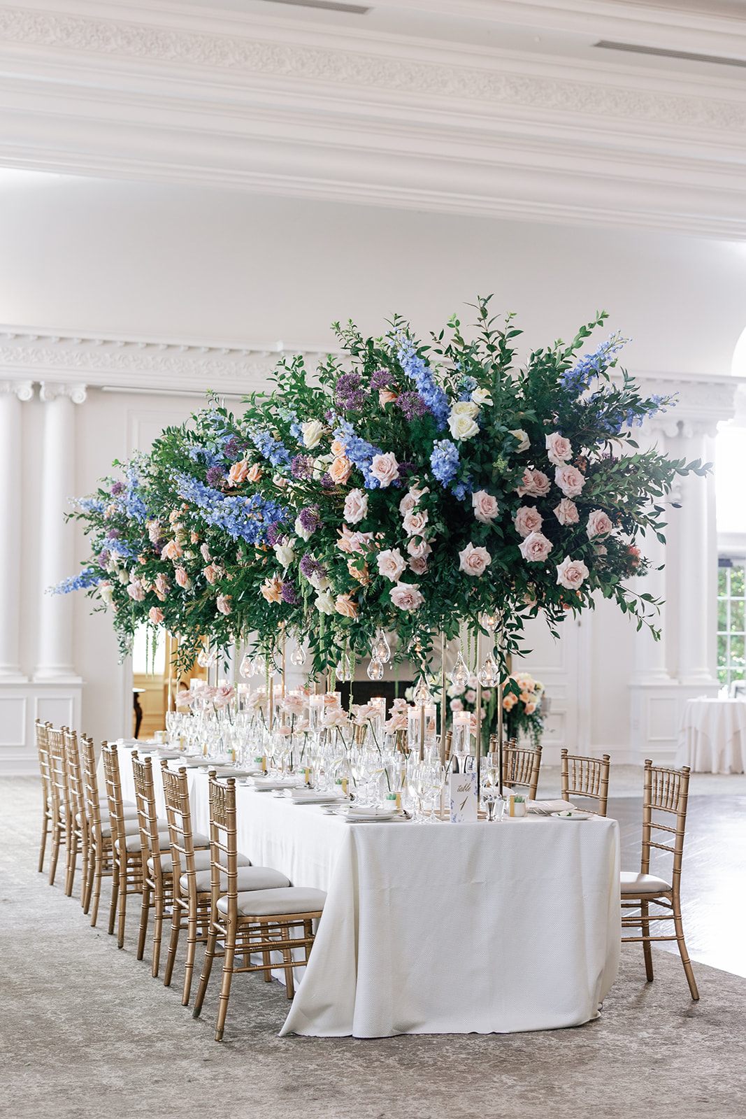 A view of a long reception table at a Park Chateau Wedding with large tall floral centerpieces